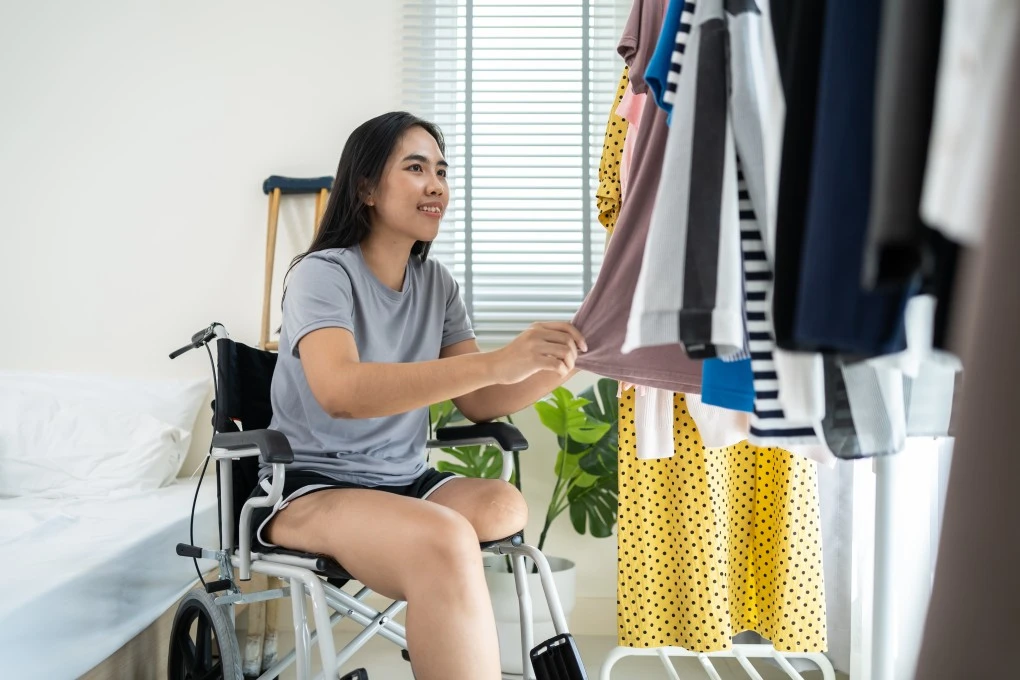 Disabled woman in her wheelchair choosing her clothes