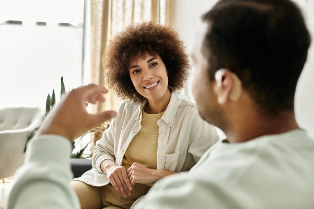 A disabled man and his support worker talking in the living room